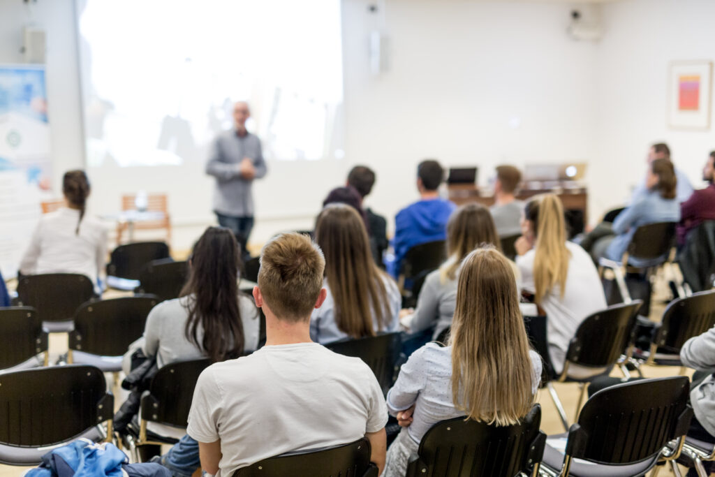 instructor speaks in front of class